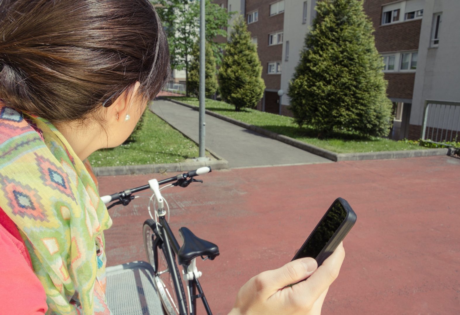 Sportive woman with fixie bike looking smartphone